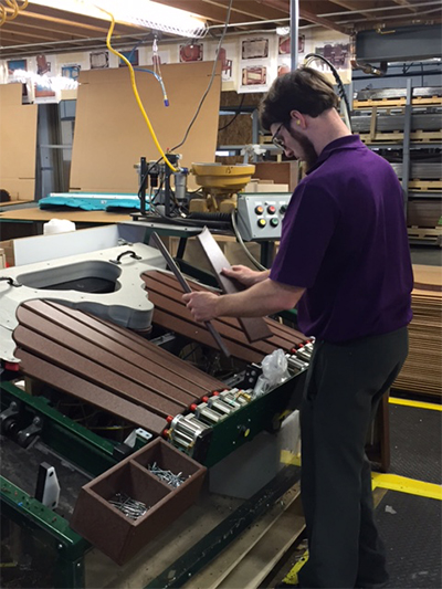 Woodworker at Berlin Gardens assembling a chair with technology.