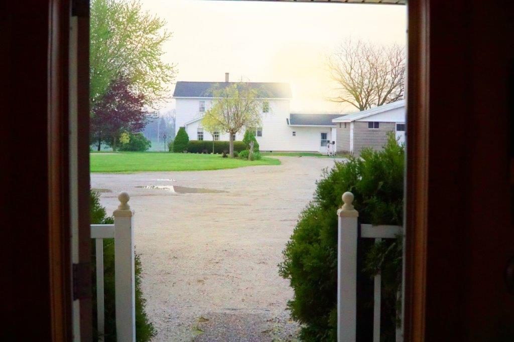 The view from the front door of a woodshop: the rising sun and the home of the woodshop owners. 