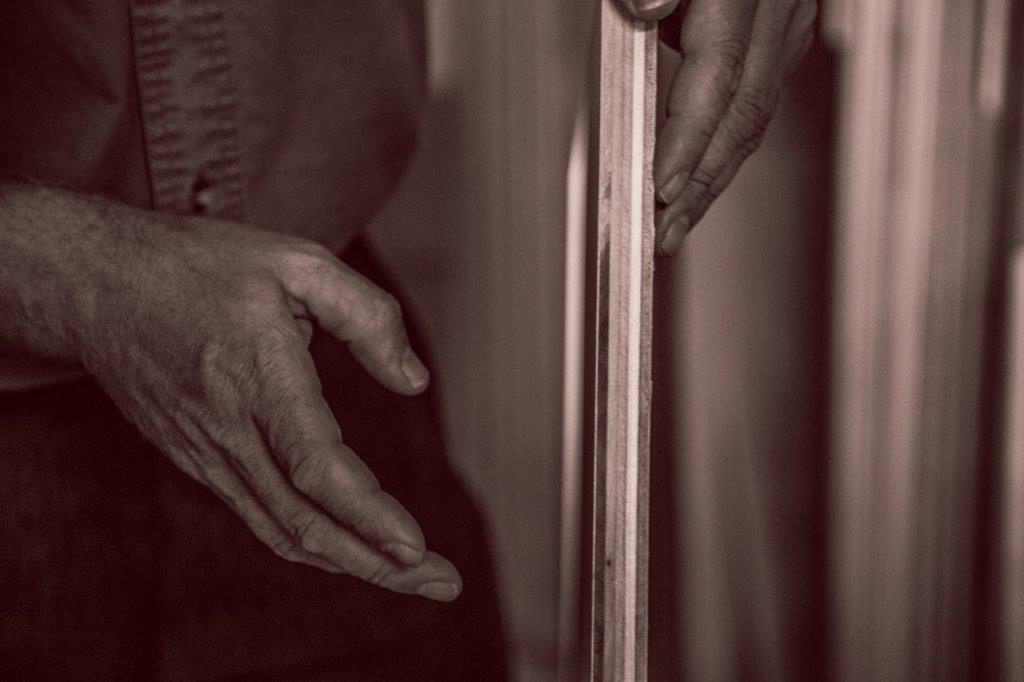 woodworker shows the details of a piece of furniture.