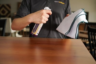 Cleaning  a wood table.