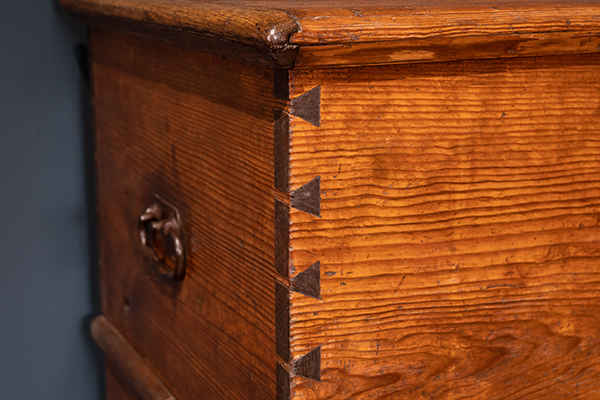 Close up on a solid wood chest with exposed dovetail joints at Kauffman Museum in North Newton, KS
