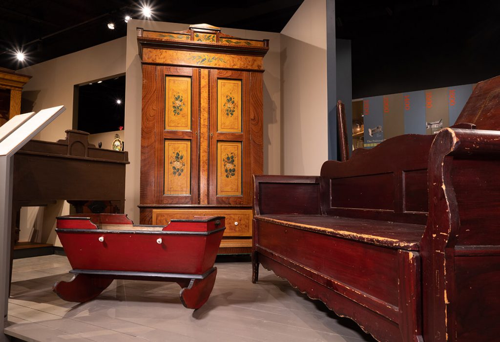 An antique Mennonite-made wardrobe, cradle, and day bed on display in Kauffman Museum, North Newton, KS