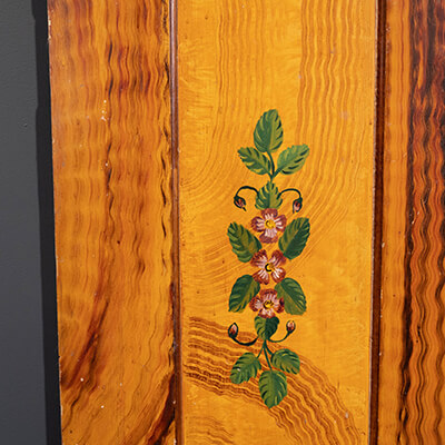 A door is decorated with rippled lines and a colorful floral painting at Kauffman Museum