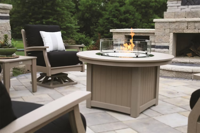 Berlin Gardens Donoma Poly Fire Pit with a flame lit in an outdoor patio setting
