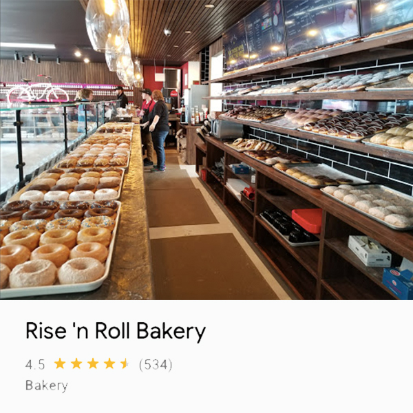 Photo of donuts and employees from the end of and behind the counter at Rise 'n Roll